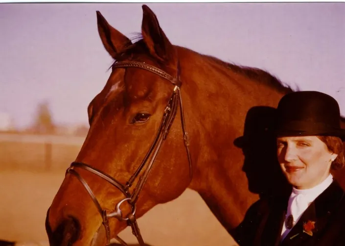 Laura Huff, on-site trainer at Mountain View Ranch, riding a bay horse in a dressage portrait